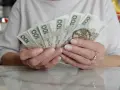 Dłonie trzymające polskie banknoty 100 i 500 zł. Numerologia 8 z dnia urodzenia może symbolizować stabilność finansową.