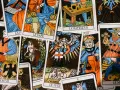 Rozłożone karty tarota, w tym "Le Pape" i "Le Bateleur". Wśród nich widać postacie aniołów i ludzi, jakby kapłan tarot odsłaniał tajemnice przyszłości.