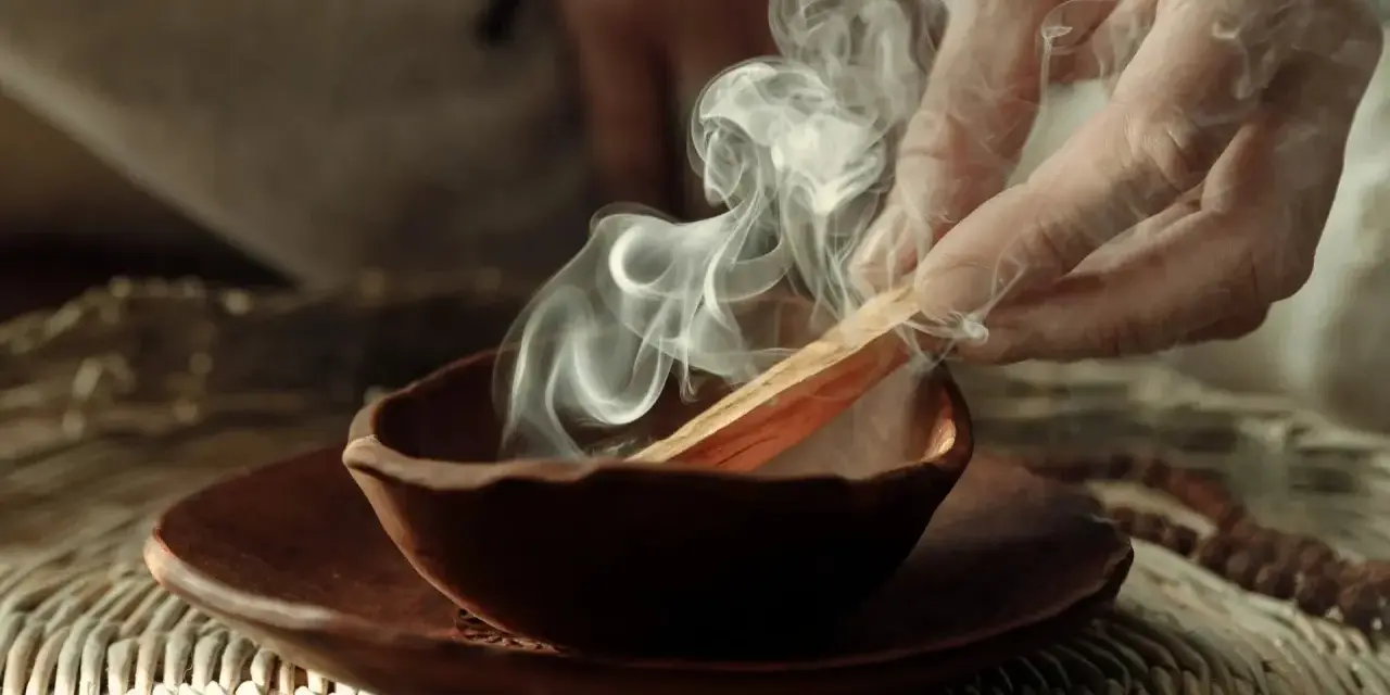 Dym z kadzidła palo santo unosi się z glinianej miseczki. Poznaj, jak palić palo santo, by oczyścić przestrzeń.