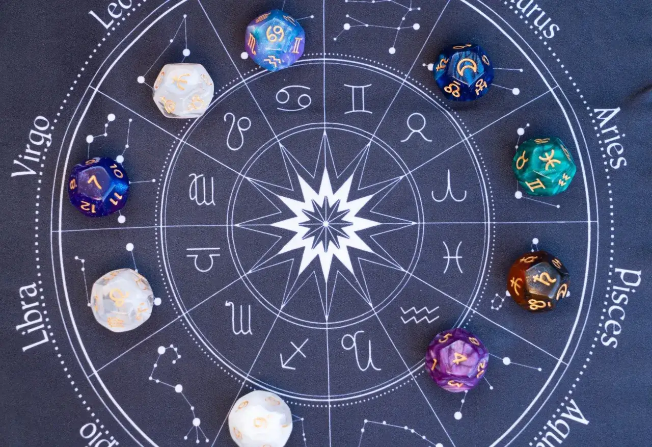 Kolorowe kostki do gry leżą na tle zodiakalnego kręgu. Każda kostka ma swoje 33 znaczenie, symbolizując gwiazdy i planety.