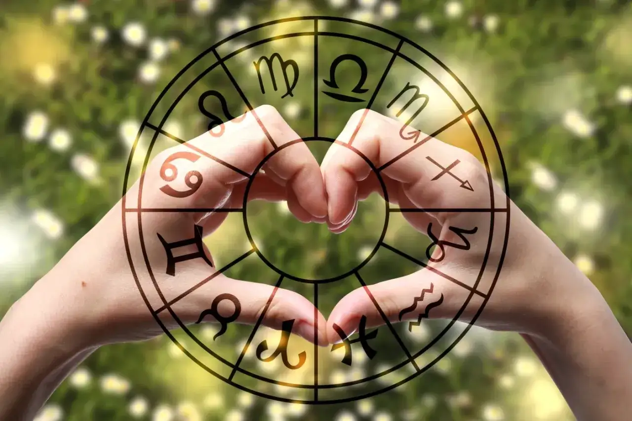 Dłonie tworzące serce w okręgu znaków zodiaku. Numerologiczna 8 w miłości symbolizuje harmonię i równowagę w związku.